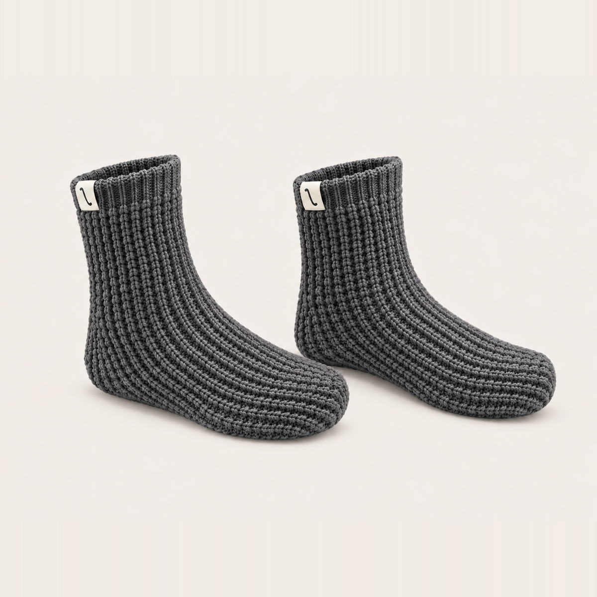 After Tracks merino waffle house socks in Ash, angled pair on a cream background